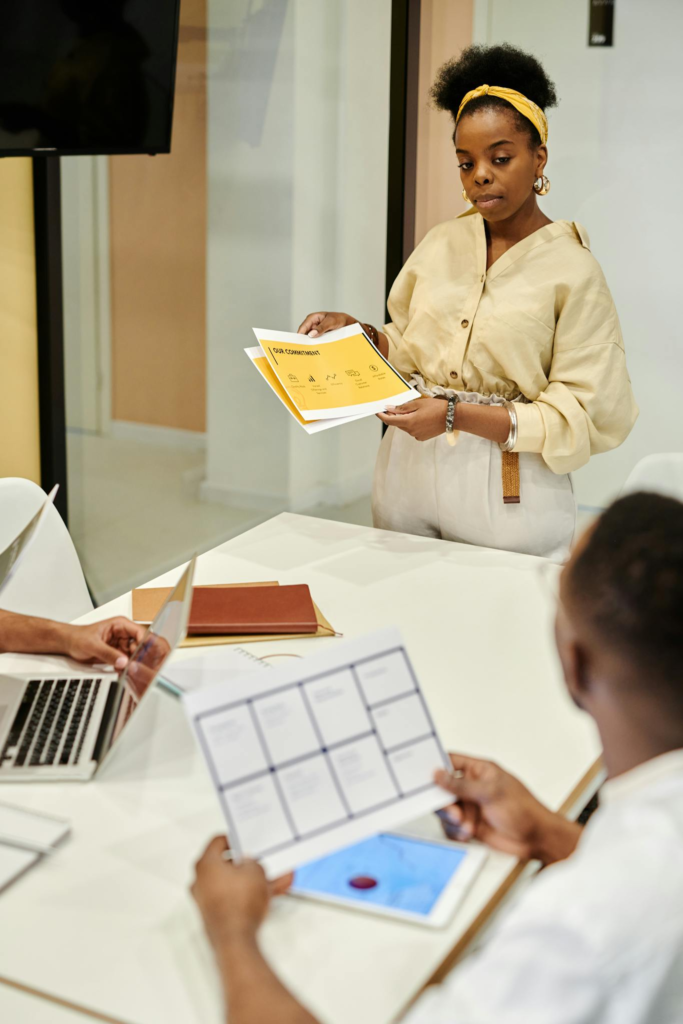A diverse team collaborates in a modern office meeting, discussing documents and presentations.